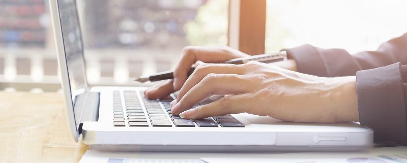 Business woman's hands typing on laptop keyboard تماس با ما